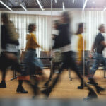Homepage - Businesspeople walking at modern office. Group of business employees at coworking center. Motion blur. Concept work process. Wide image